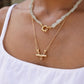 Indian inspired hand made solid silver 22k Gold plated bar necklace with a pendant on a person wearing a white top.